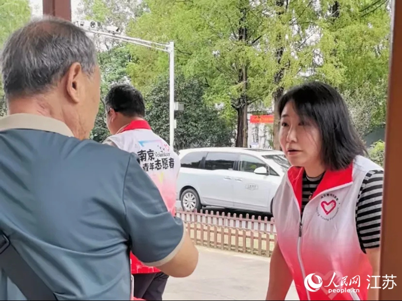 景区门口,志愿者在为游客讲解乘车路线。人民网 崔小倩摄