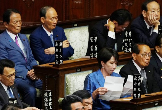 10月21日,在日本东京,自民党总裁高市早苗(前排右二)在临时国会众议院首相指名选举现场阅读文件。新华社记者贾浩成摄