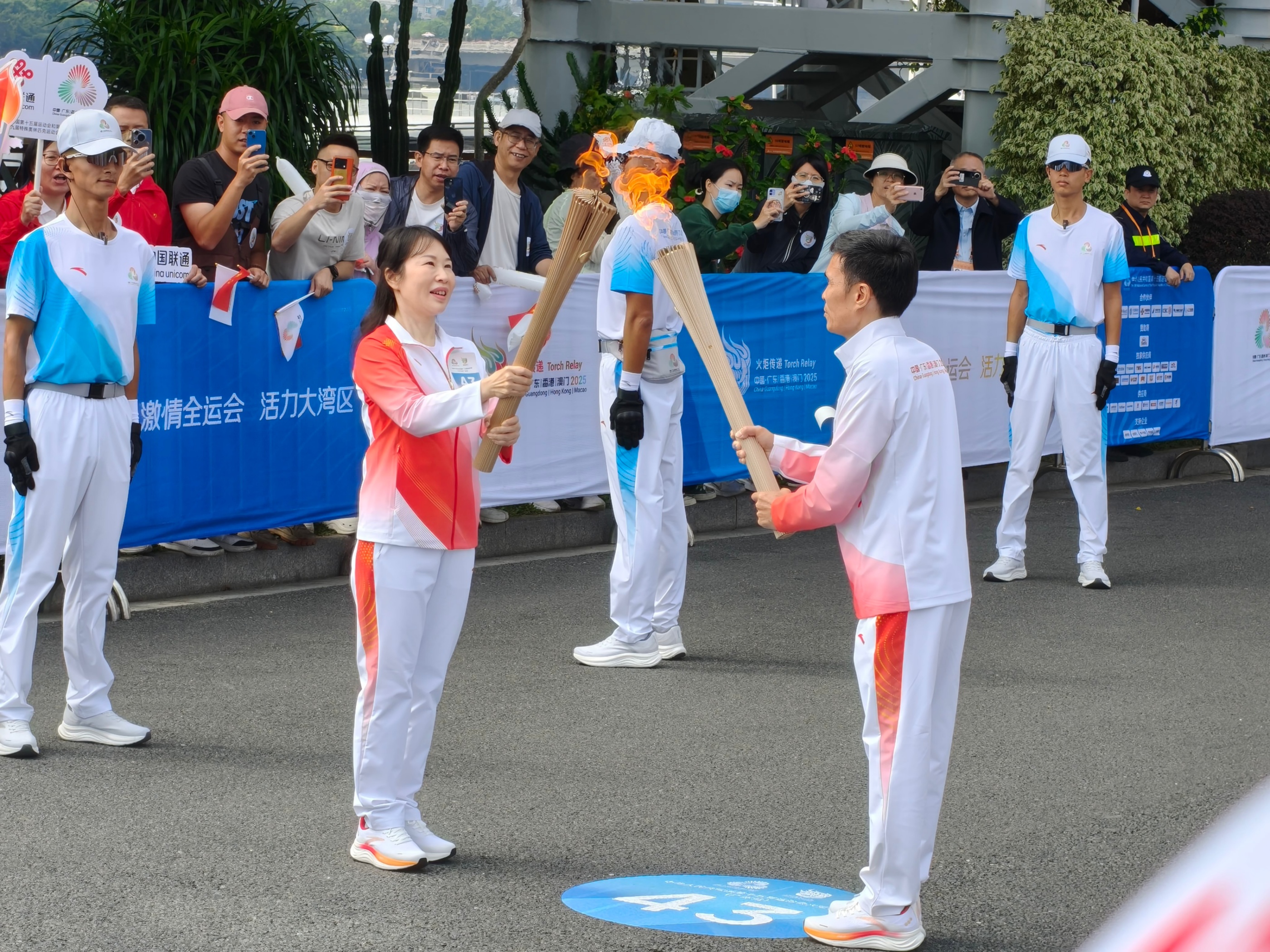 11月2日,十五运会火炬在广州传递,第42棒火炬手冯至佳与第43棒火炬手周立松交接圣火。