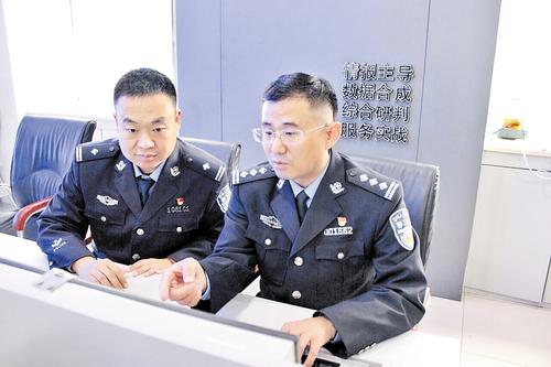 10月30日，许俊富（右）与同事在分析案情。 本报记者 桑珊摄