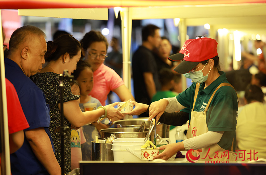 石家庄赛场外“足球市集”,络绎不绝的观众排队品尝石家庄特色美食。人民网记者 李兆民摄