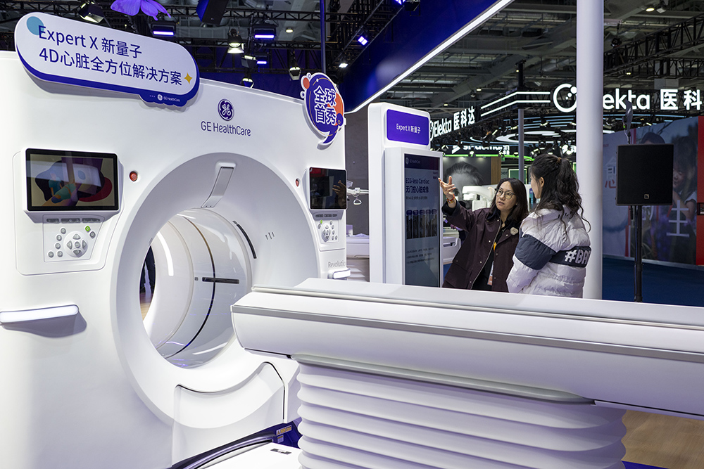 GE医疗展台，工作人员正在介绍全球首秀展品。人民网记者 翁奇羽摄