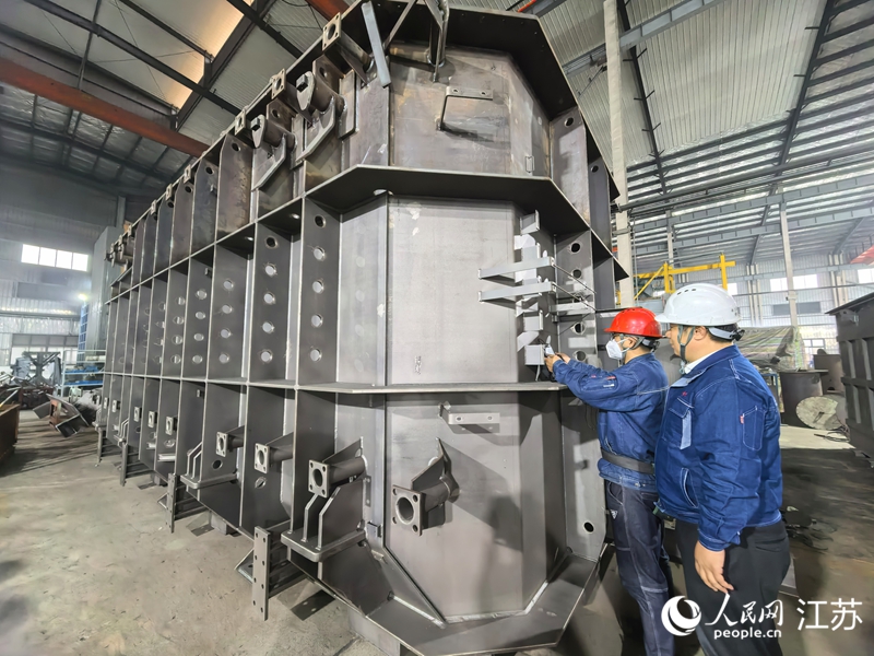 志和电气工程师检测大型变压器配件。人民网记者 王继亮摄