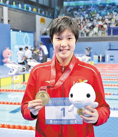 11月17日，于子迪展示本届全运会获得的第三枚金牌。 本报记者 耿 辉摄
