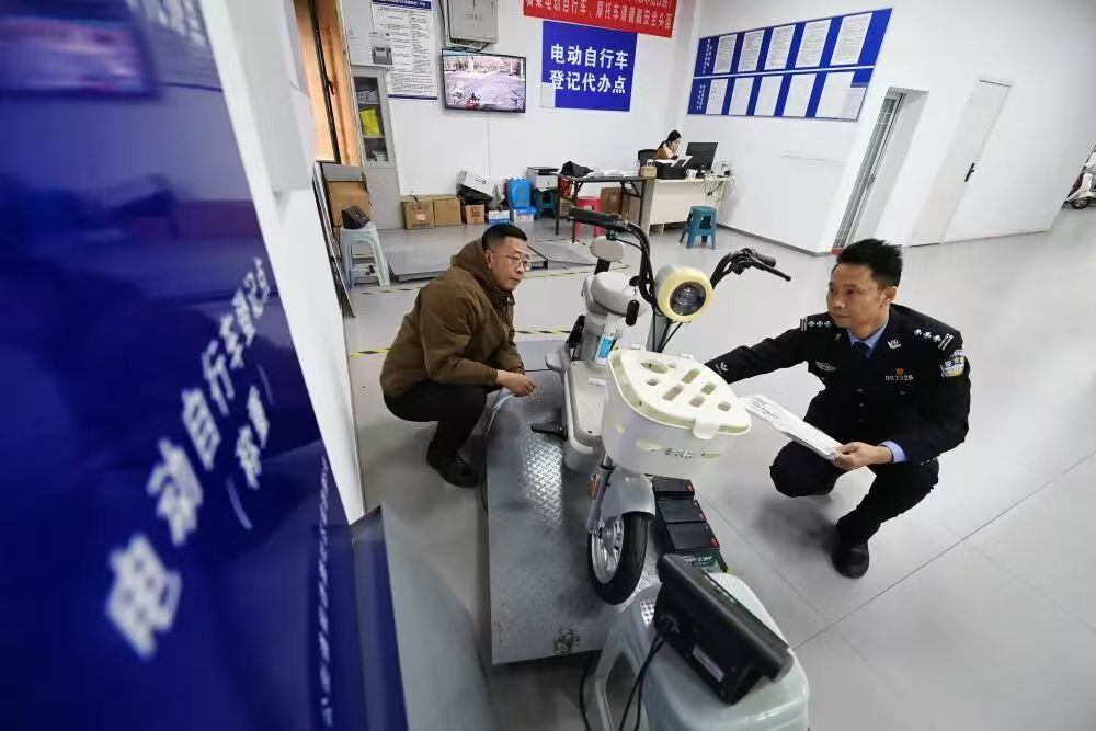 12月1日,湖北省襄阳市交警支队车管所民警按新国标流程查验电动自行车。新华社发(谢勇摄)