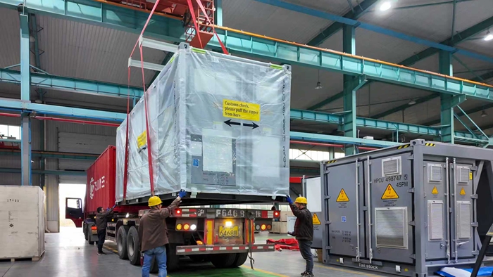 在工作人员指挥下,储能一体机稳稳放在等待“出海”发运的重卡上。受访者供图