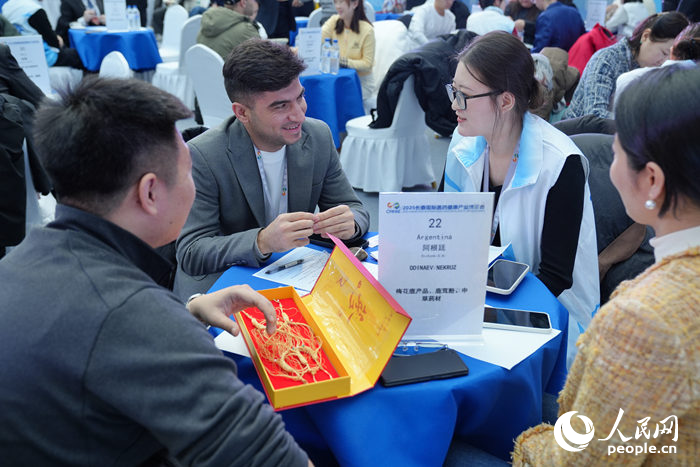 海外采购商与医药代表洽谈。人民网记者 李洋摄