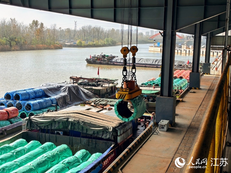 机械臂抓起钢帘线盘条,通过专用传输带直运到生产车间。人民网 崔小倩摄