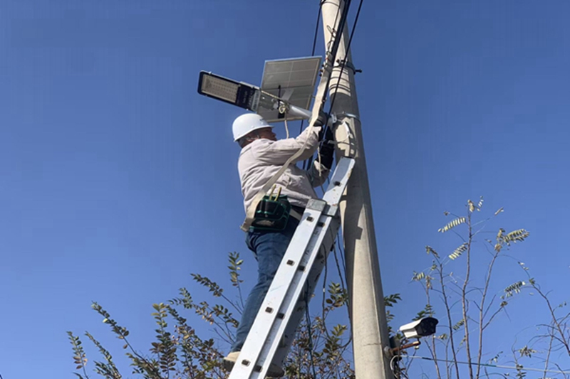工作人员正在安装调试太阳能路灯。郭勇志摄